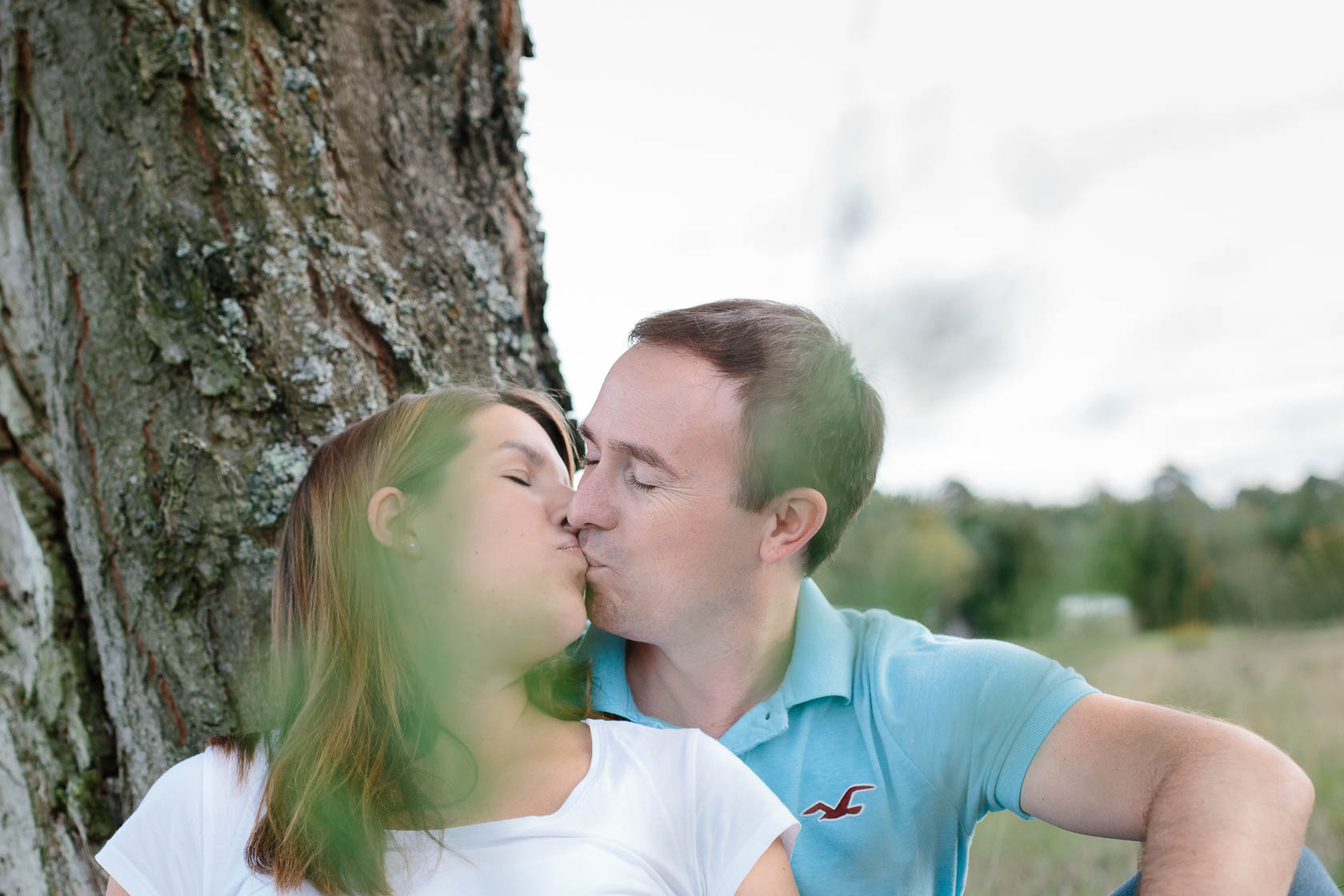 Entspanntes Paarshooting und Babybauch Shooting in der Natur bei Waghäusel. Küssendes Paar.