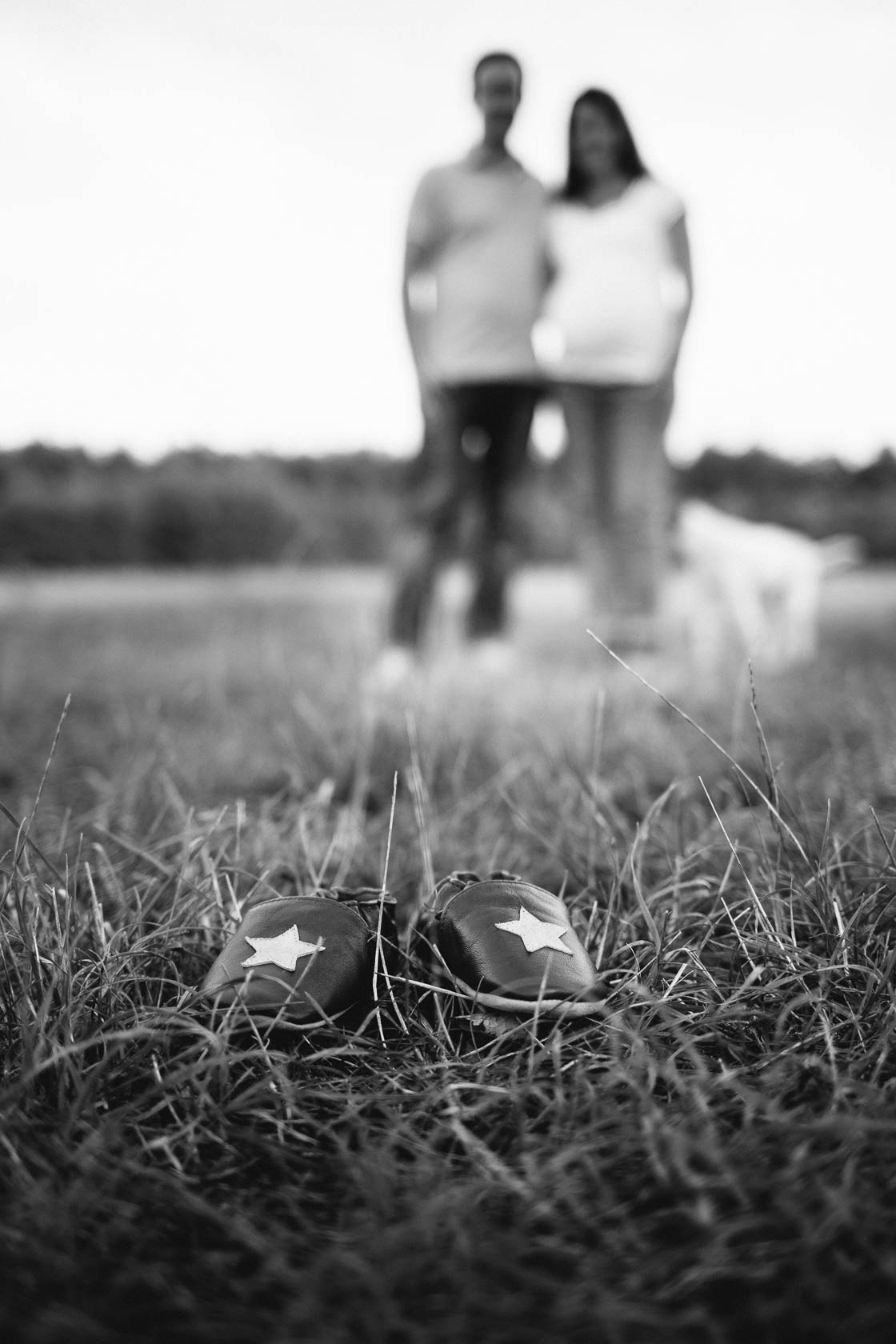 Entspanntes Paarshooting und Babybauch Shooting. Kleine Schuhe auf der Wiese.