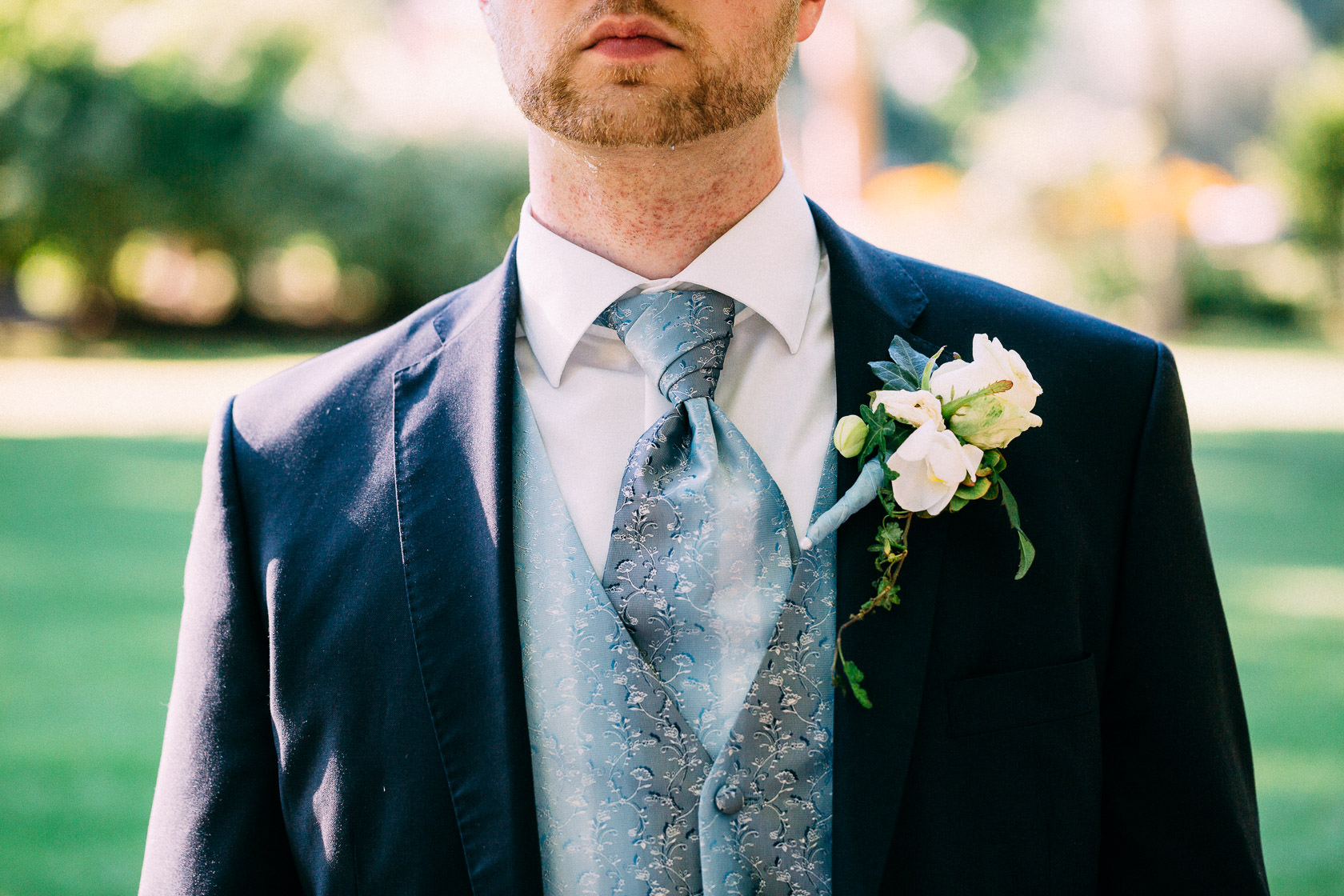 Blauweiße Hochzeit in Bad Kreuznach Paarfotos im Kurpark Details Bräutigam Blumenschmuck und Ringe