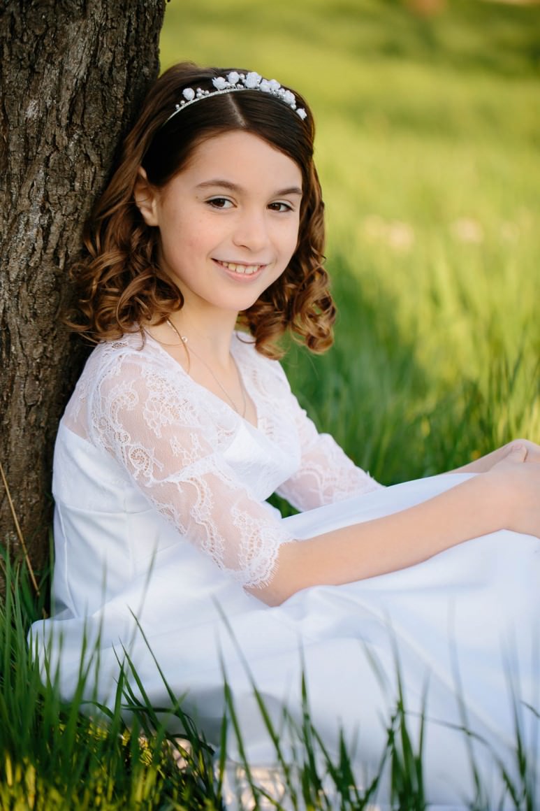 Entspannte Kommunionbilder in der Natur bei Philippsburg Kommunionkind weißes Kleid Obstwiese mit Blumen Frühlingswiese